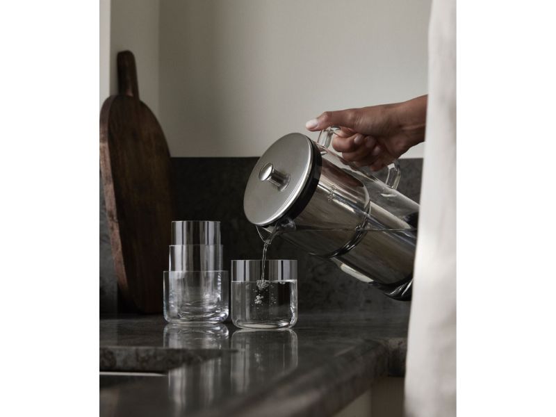 Bild einer Küche, in der gerade reines Wasser aus dem Aarke Purifier in ein Glas geschüttet wird.
