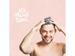 Lachender Mann seift sich das Haar ein neben einem It's-Show-time-Schriftzug
